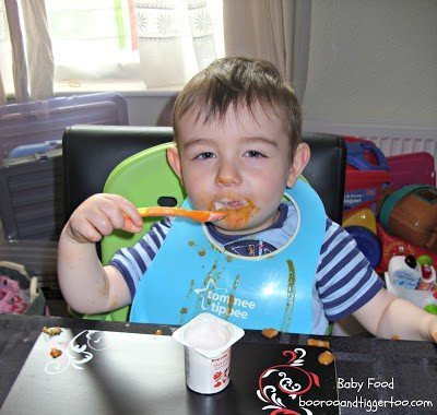 A little boy sitting at a table eating food