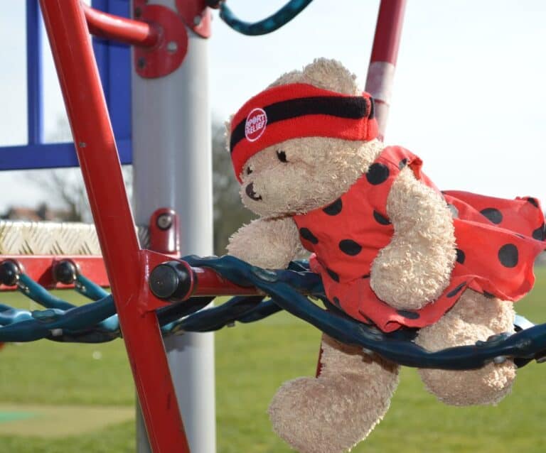 A teddy bear sitting on top of a pole