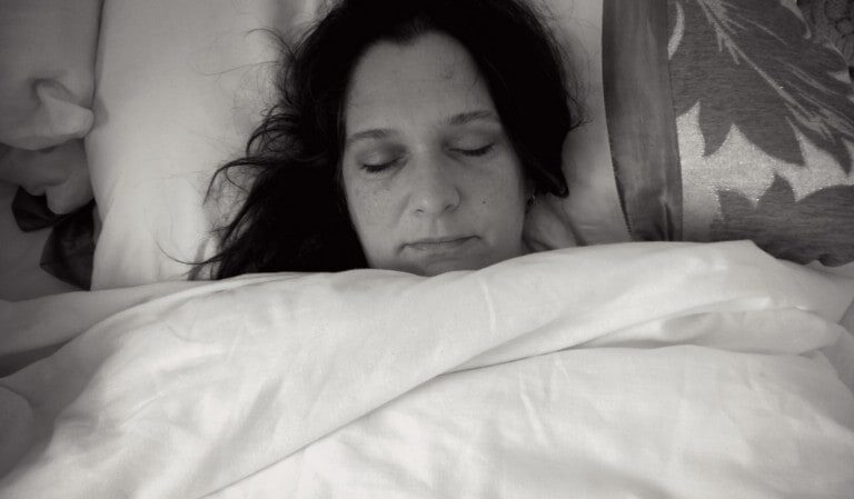 A close up of a woman lying on a bed