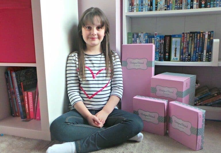 A young girl sitting in front of a book shelf