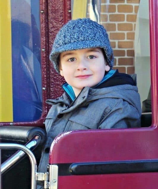 A little boy sitting on a suitcase