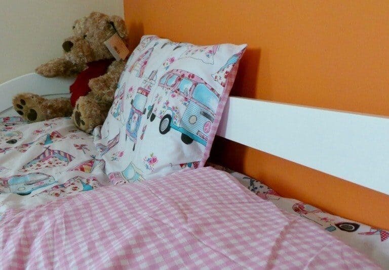 A teddy bear sitting on top of a bed