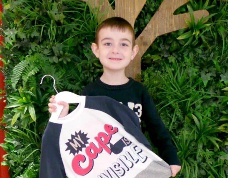 A young boy holding a plant in a garden