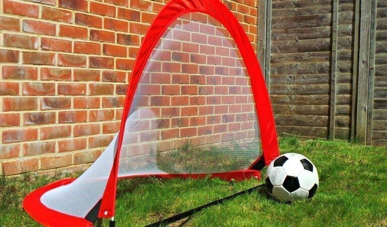A close up of a football ball in front of a brick building