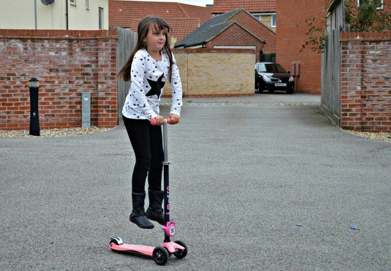 A young girl holding a football ball