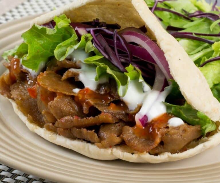 A sandwich and salad on a plate, with Kebab