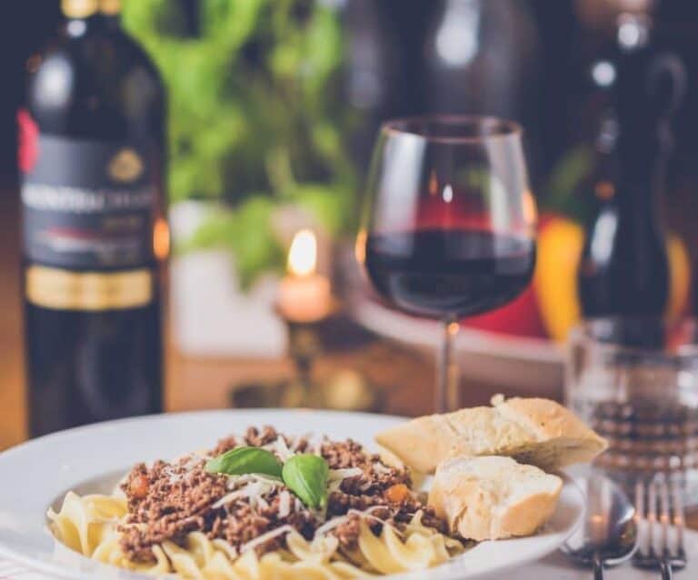 A plate of food and a bottle of wine on a table, with Dinner