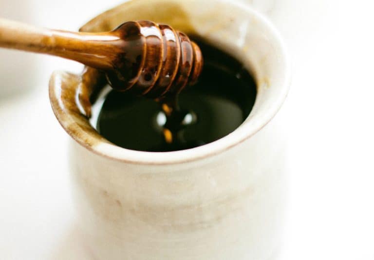 A close up of a coffee cup, with Honey and Sugar