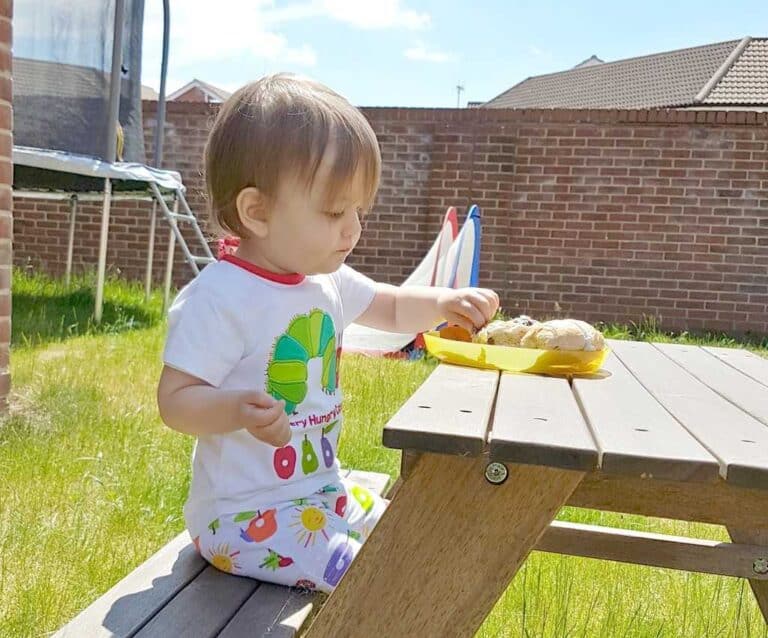 A little boy sitting at a picnic table