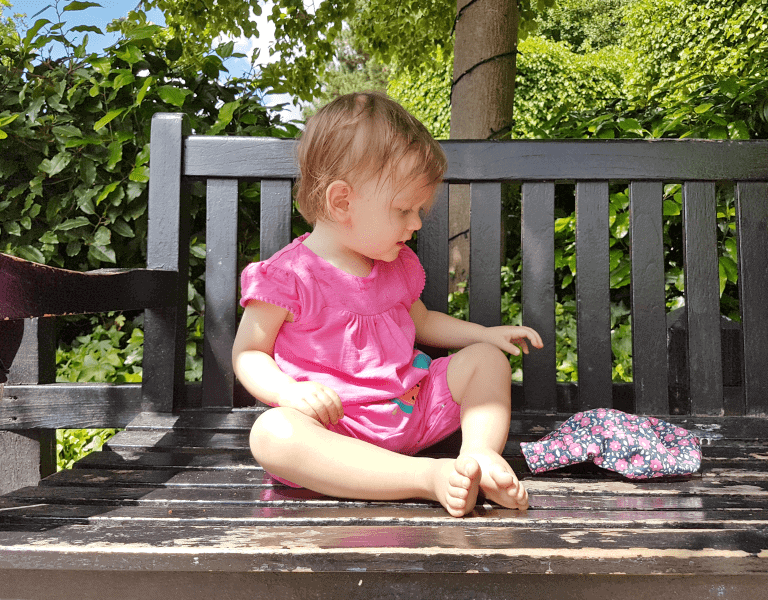 A little girl sitting on a bench