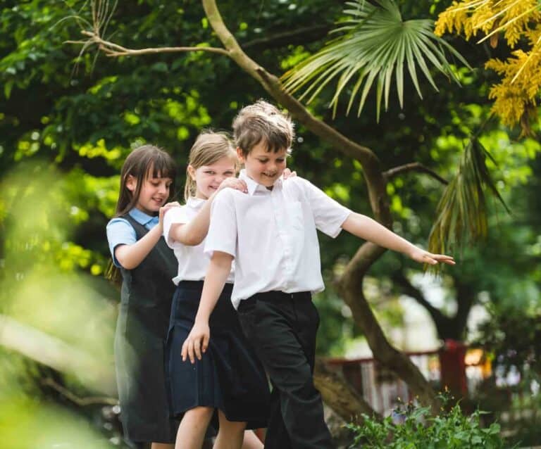 A young boy standing next to a tree