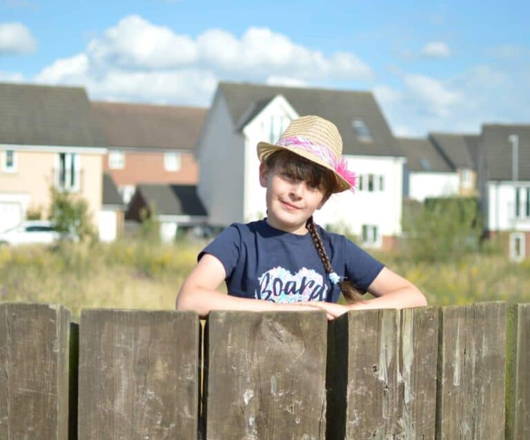 A young boy sitting on a wooden bench