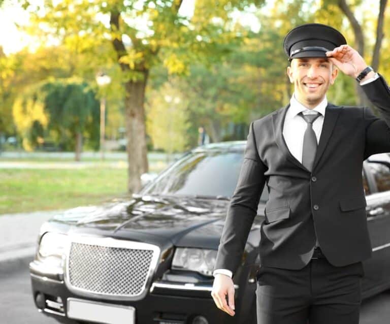 A man wearing a suit and tie standing next to a car