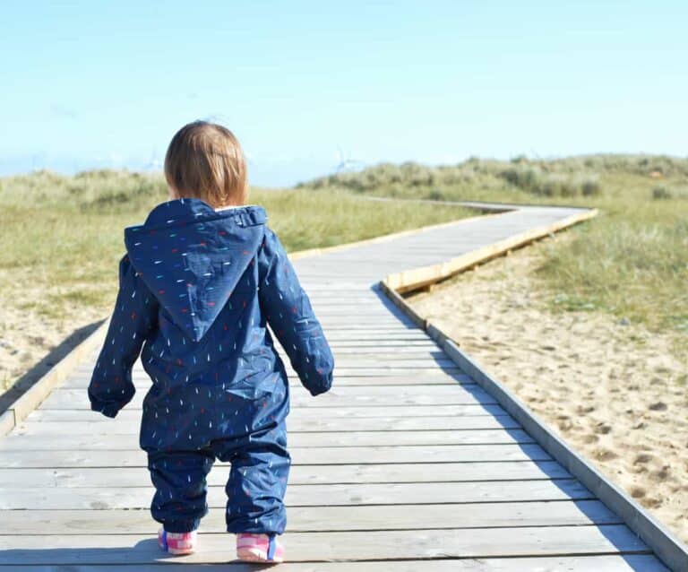 A little boy that is standing in the sand