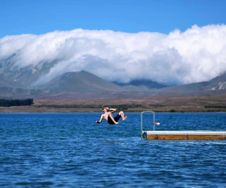 A small boat in a body of water with a mountain in the background