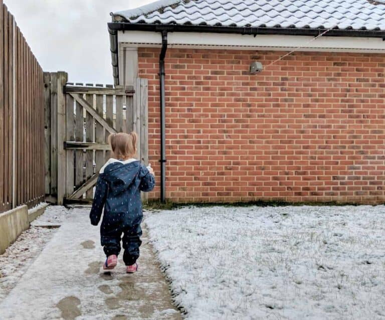 A person standing in front of a brick building