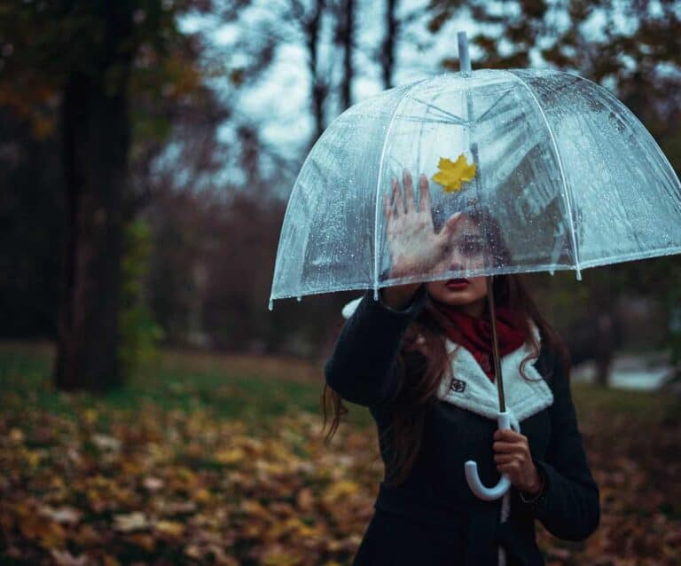 A woman walking in the rain holding an umbrella