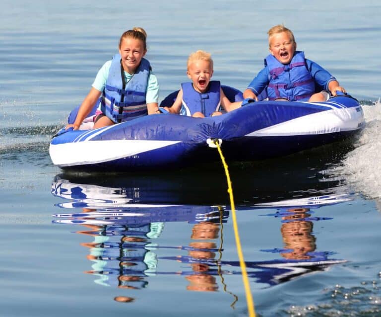 A man riding on the back of a boat in the water