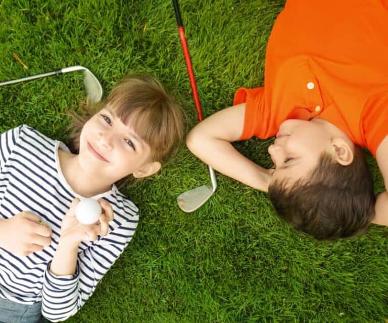A little boy that is lying down in the grass
