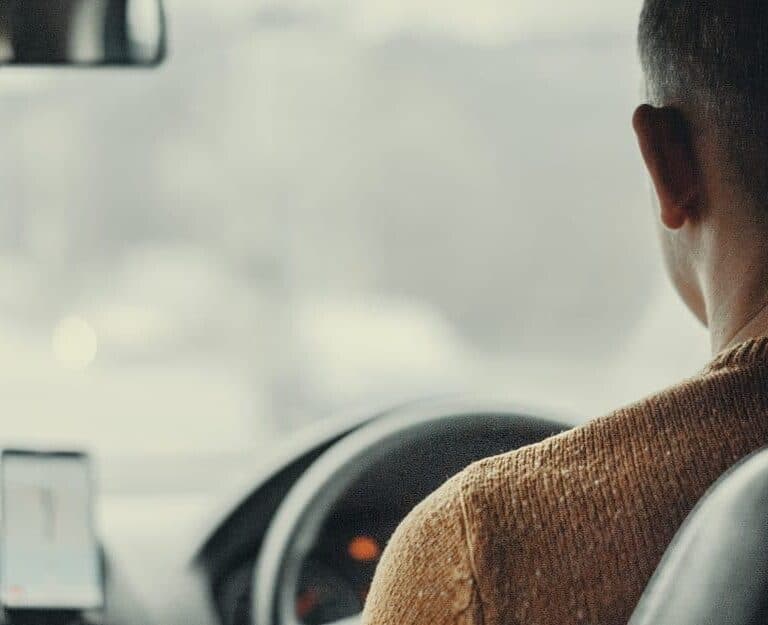 A close up of a man driving a car