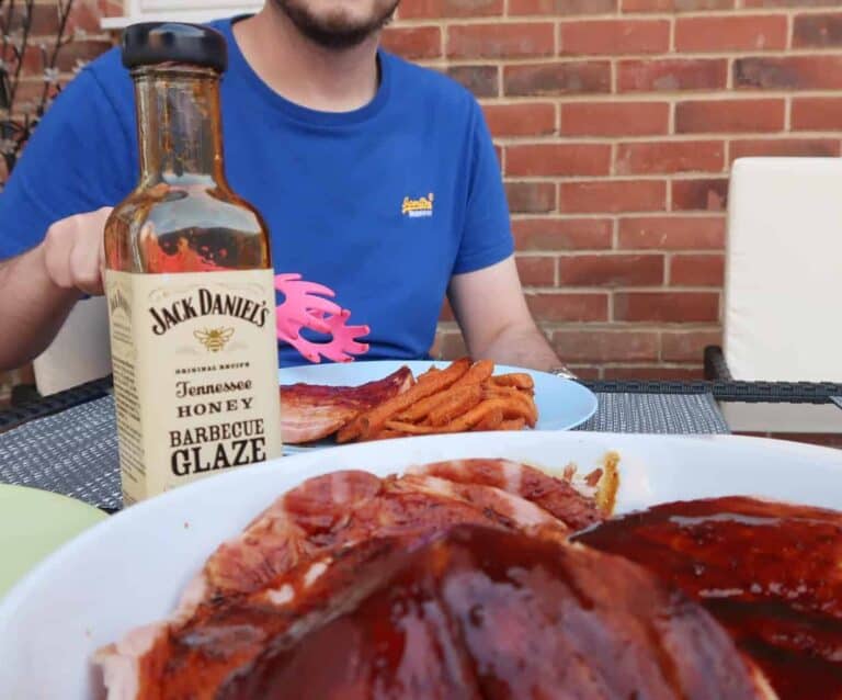 A person sitting at a table with a plate of food, with Barbecue and Gammon