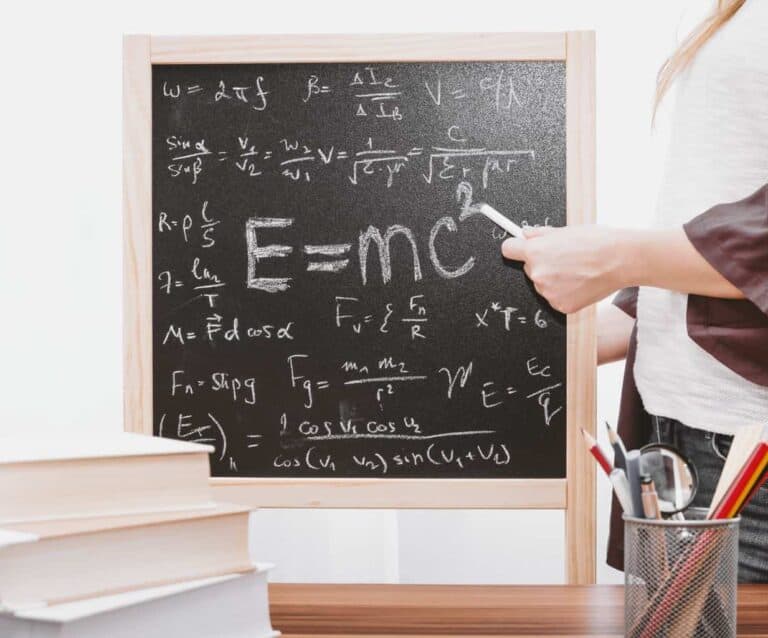 A person standing in front of a blackboard