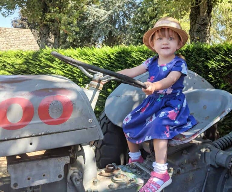 A little boy that is sitting on a bench posing for the camera