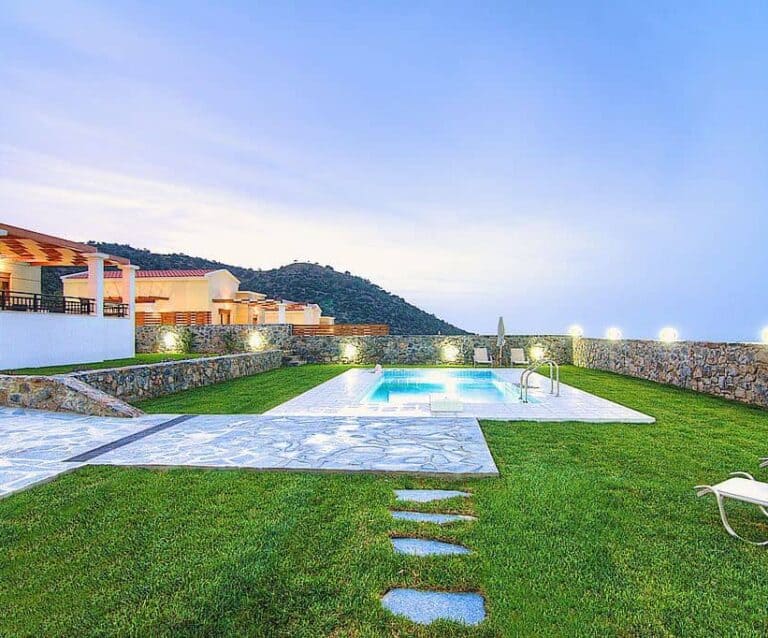 A couple of lawn chairs sitting on top of a grass covered field