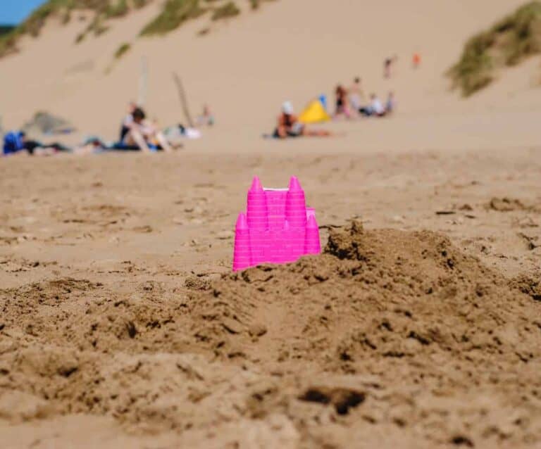 A group of people standing on top of a sandy beach