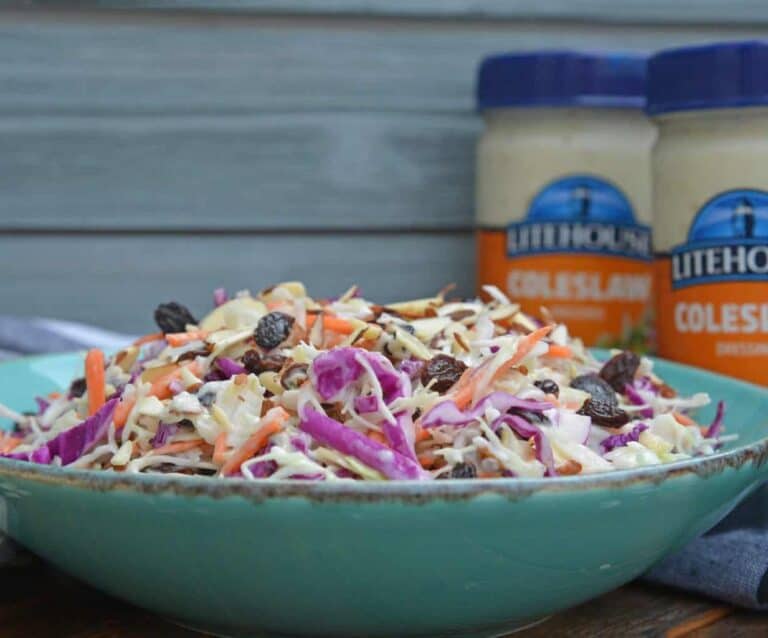 A bowl of food on a table, with Coleslaw and Raisin