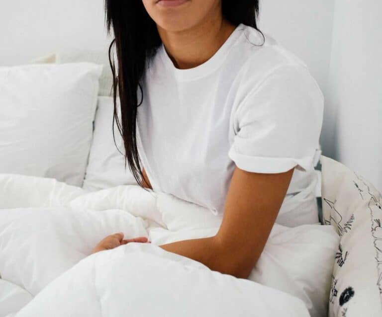 A person sitting on a bed posing for the camera