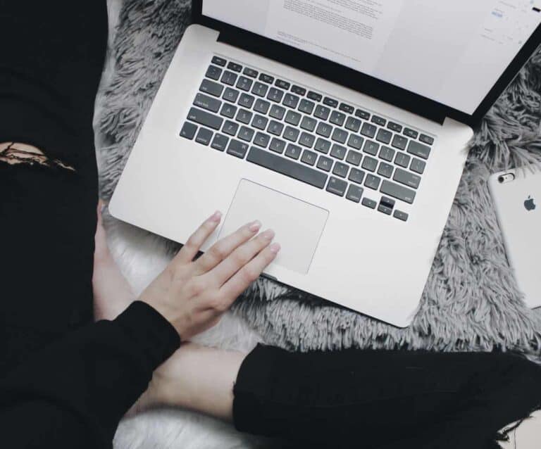 A person sitting next to a laptop