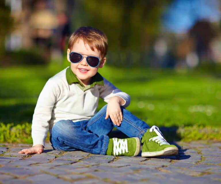 A little boy that is sitting in the grass