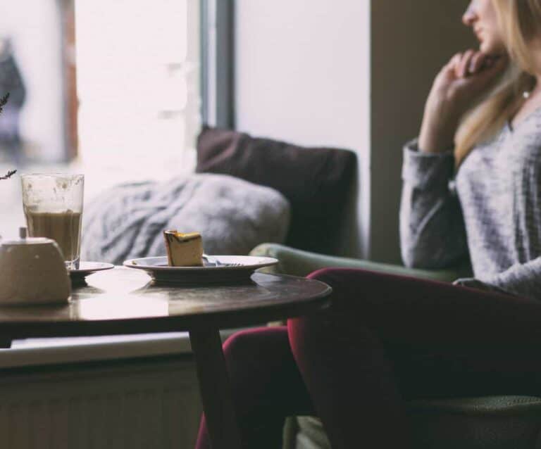 A person sitting at a table in front of a window