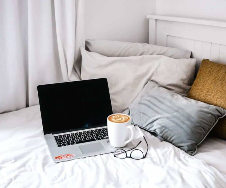 A bedroom with a bed and a laptop