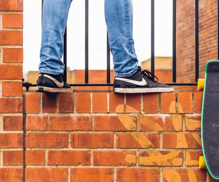 A man standing next to a brick wall