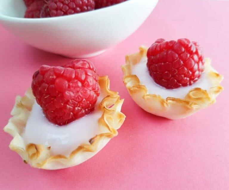 A piece of fruit on a plate, with Berry and Raspberry