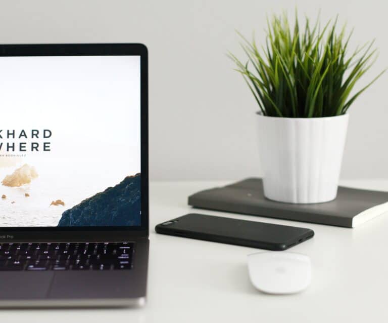 A desk with a laptop computer sitting on top of a table