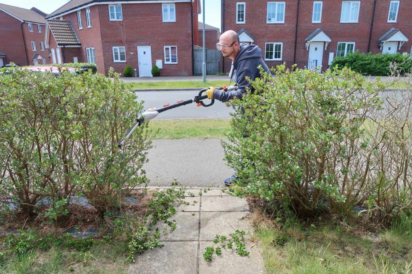 A man riding a skateboard down a street in front of a house