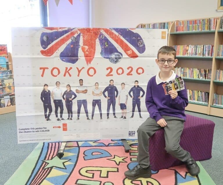 A boy sitting in front of a book shelf