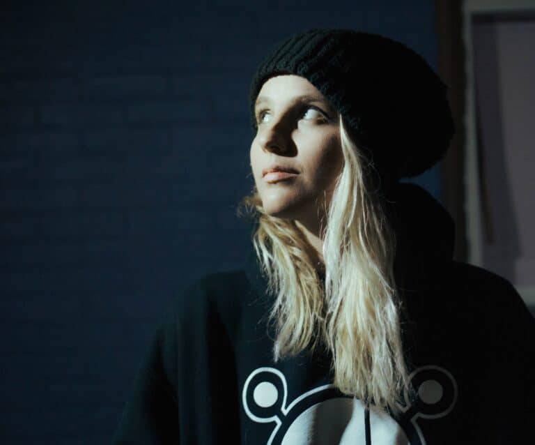 teenager wearing a jumper and hat looking moody