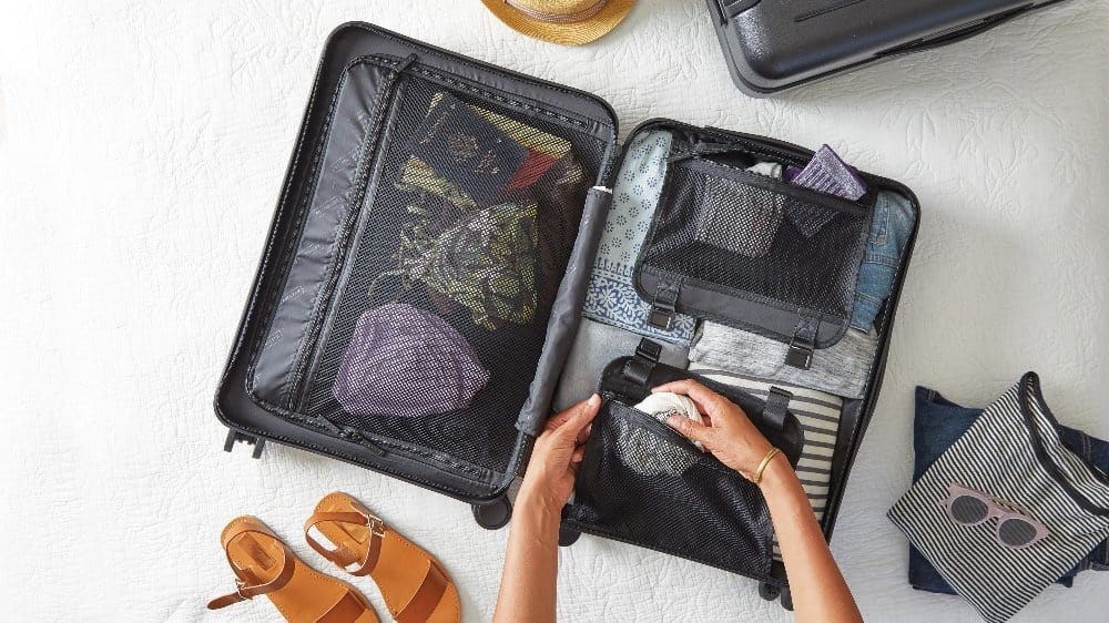 A person lying on top of a suitcase