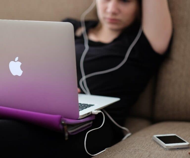 A person sitting at a table using a laptop computer