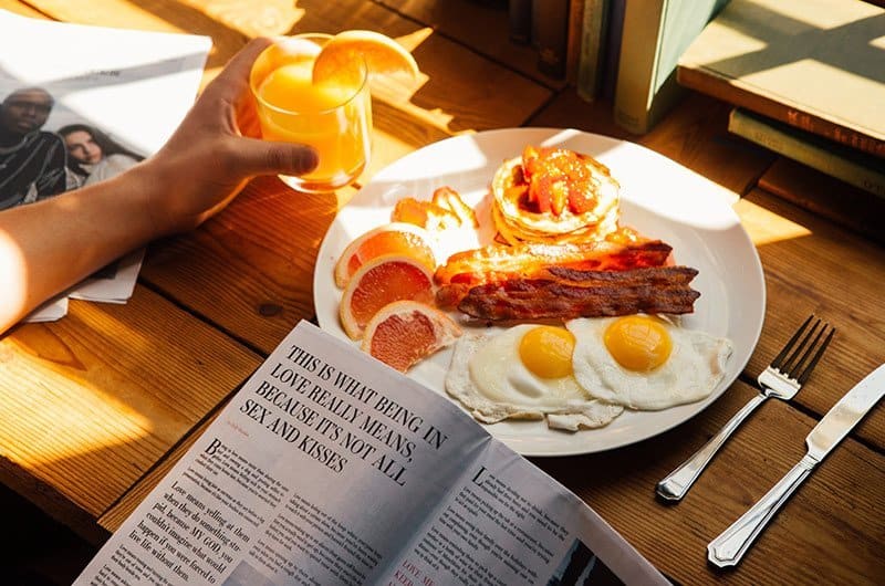 A plate of food sitting on top of a wooden table, with Restaurant and Sandwich