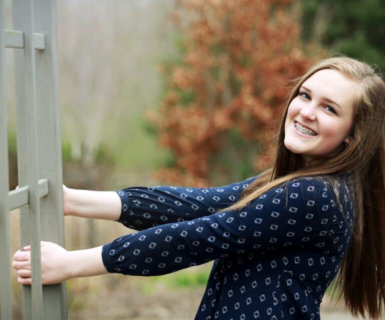 A woman standing in front of a fence