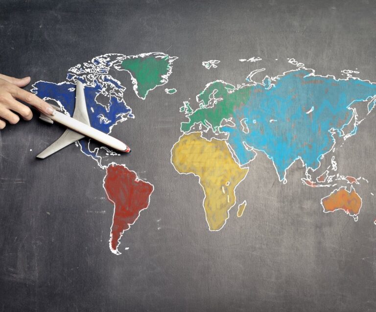 Top 5 Business Ideas for Travelers - person with toy airplane on world map