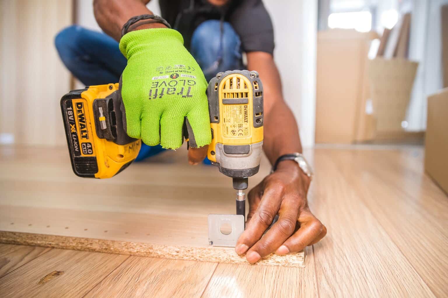 Tips to Save Money on Your Home Refurb - person using dewalt cordless impact driver on brown board