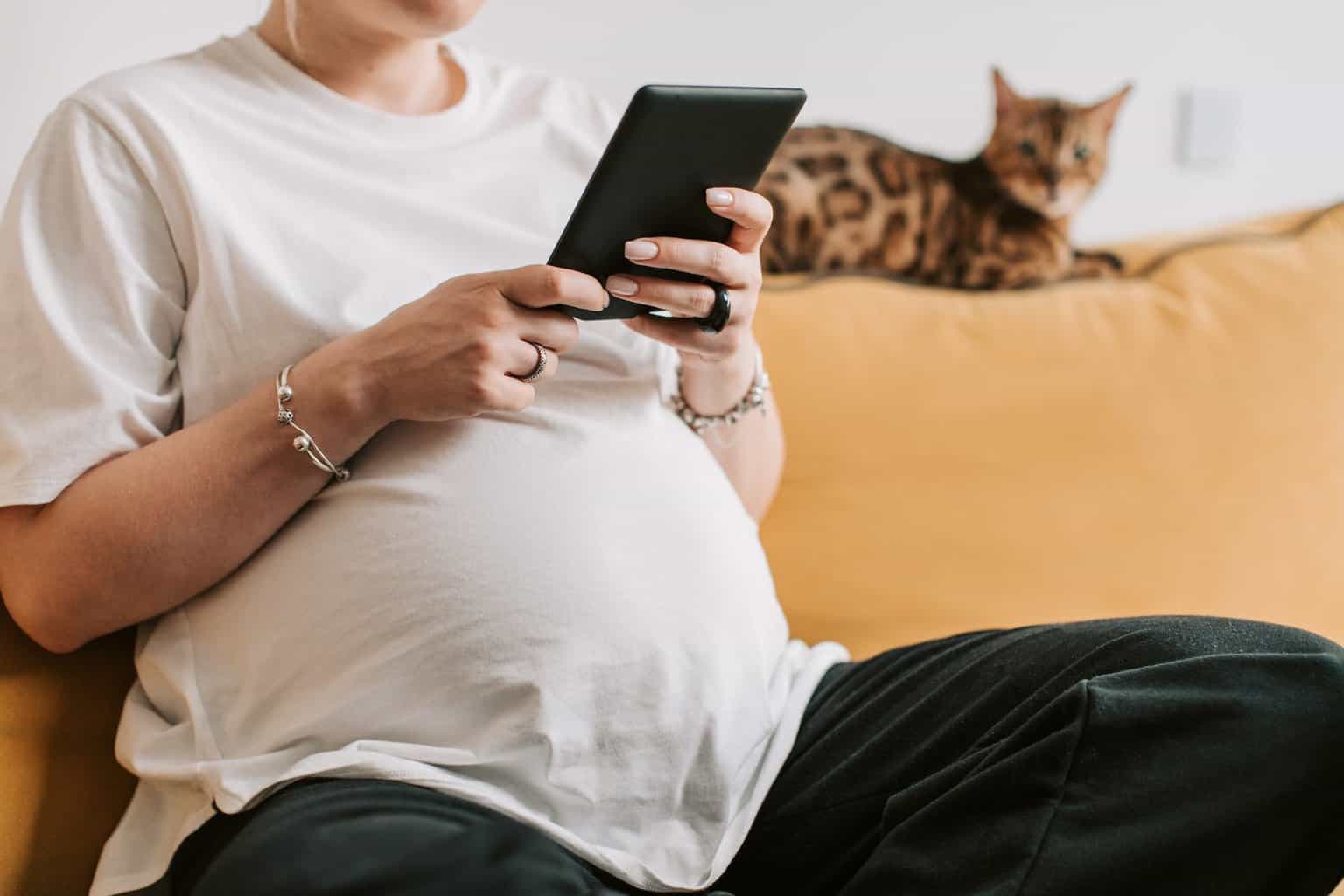 mortgage on maternity leave - pregnant woman in white shirt holding a tablet