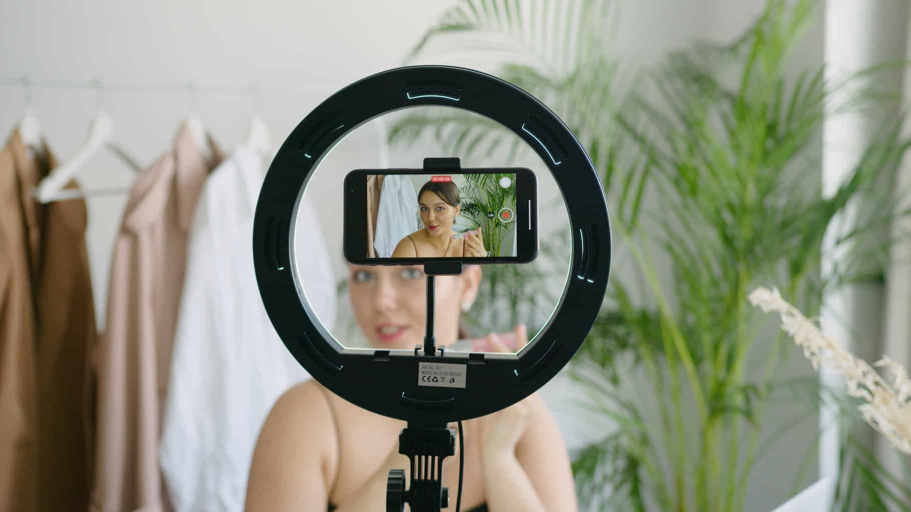 a woman video recording herself using a cellphone camera - Digital Media Career Options