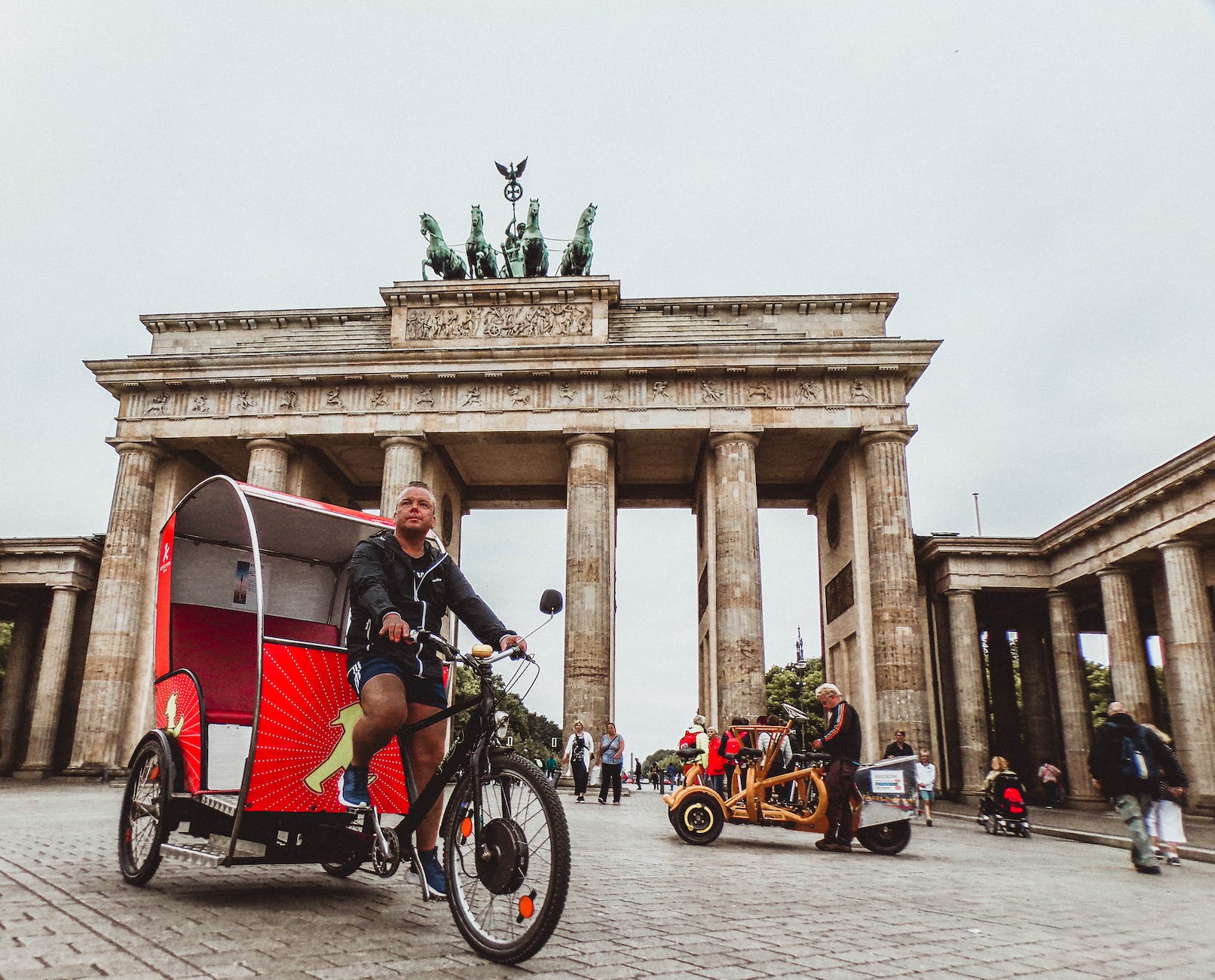 man in black hoodie riding trike - Exploring Berlin's Historic Landmarks: Brandenburg Gate